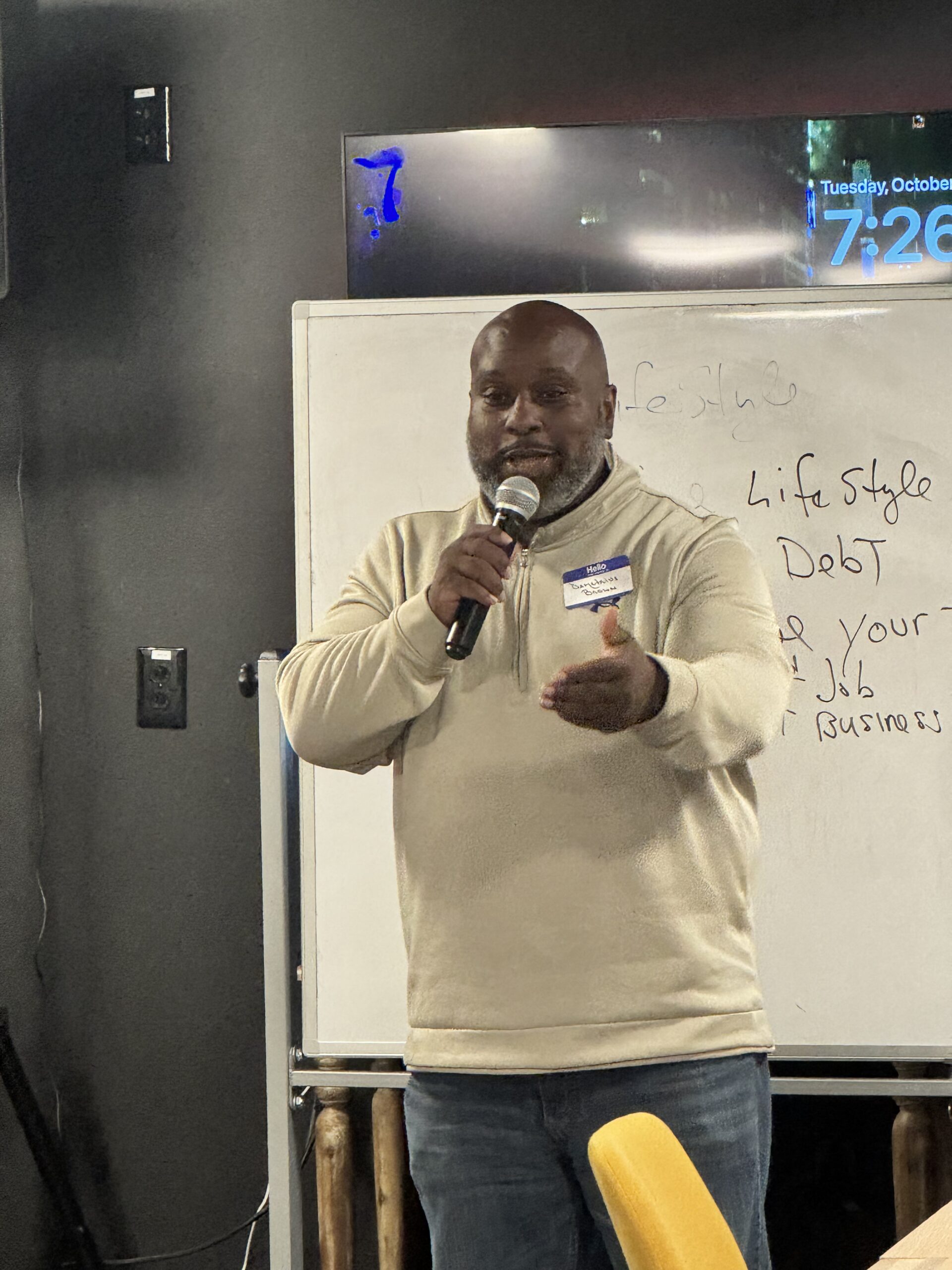 Demetrius L. Brown speaking beside a presentation board